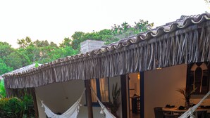 A pool area with a hammock, lounge chairs, and a dining area. - Awe Villa Boutique e Beach Club (Porto Seguro)