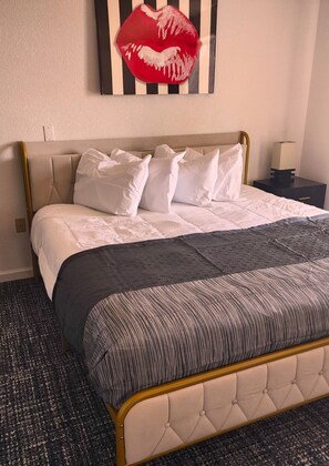Desk, laptop workspace, iron/ironing board, bed sheets