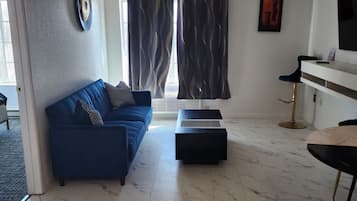 Relax in this stylish living room with a sofa, ottoman, and flat-screen TV.