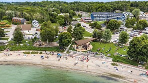 En kuststad med en sandstrand, en lekplats och en stor byggnad med flera balkonger.