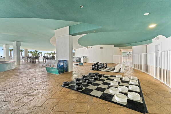 A spacious indoor area with a checkered floor, a chessboard, and a sign. - Turquoise D806 (Orange Beach)