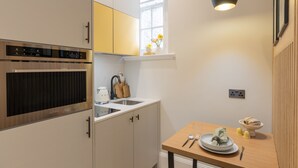 A modern kitchen with a built-in oven, a sink, and a window above the countertop.