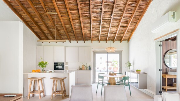 A modern kitchen with white cabinets, a wooden ceiling, and a dining area with two chairs and a table. - RURAL HOUSE CERCADO DE DON PACO (Santa Lucia De Tirajana (Capital Municipal))