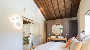 A bedroom with a large bed, a round mirror, a wooden ceiling, and a view into the kitchen. - RURAL HOUSE CERCADO DE DON PACO (Santa Lucia De Tirajana (Capital Municipal))