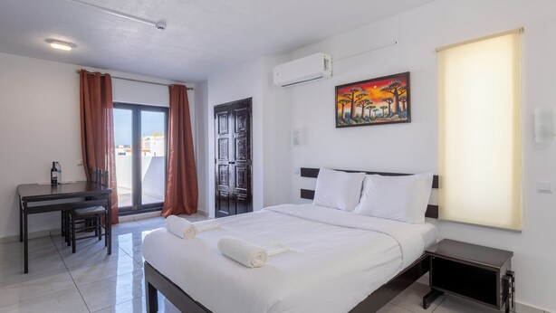 Une chambre d’hôtel équipée d’un lit, d ’un bureau, d’une chaise, d’un tableau et d’un appareil de climatisation.