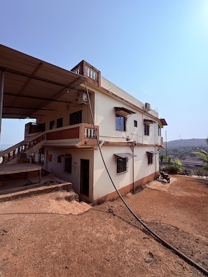 Un bâtiment à deux étages doté d’un espace extérieur abrité, d’un escalier et d’un sol en terre battue.