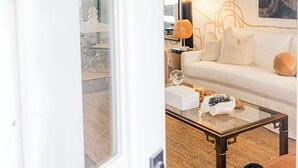 A modern living room with a white sofa, a coffee table, and a painting on the wall. - Game day luxury! New! 3 king en suites; 17 min walk to UM; 5 mins to sq; (Oxford)