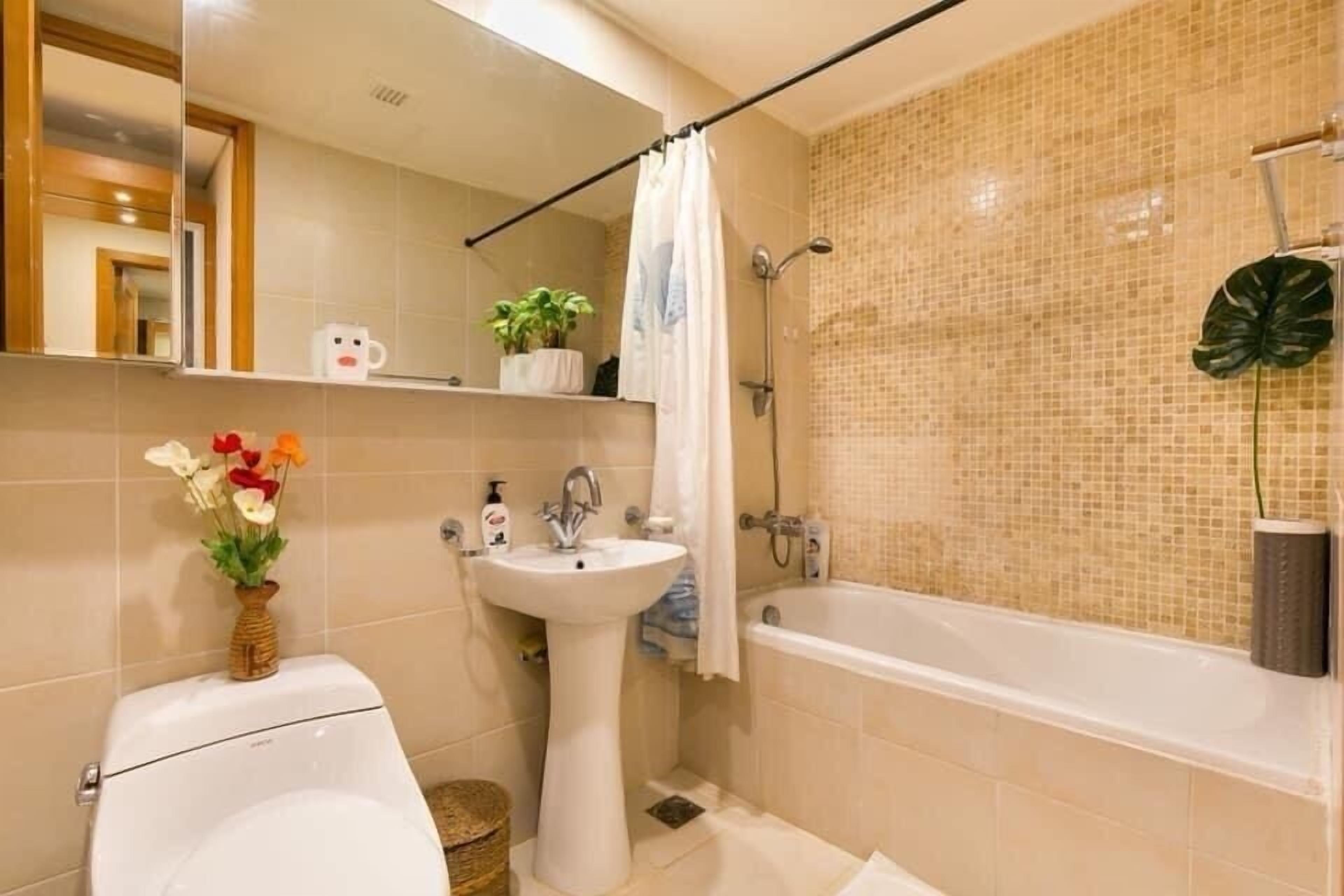 A bathroom with a toilet, sink, and bathtub.