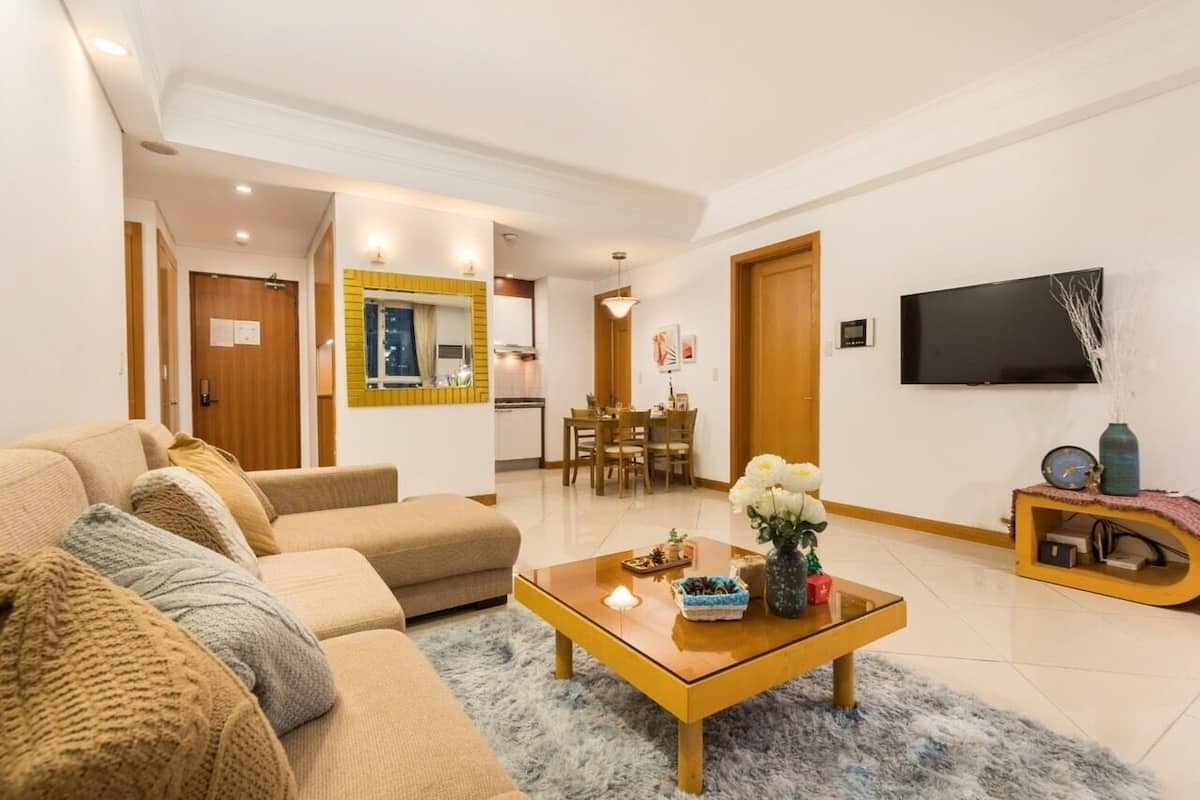 Un salon moderne avec un canapé, une table basse et un téléviseur fixé au mur.