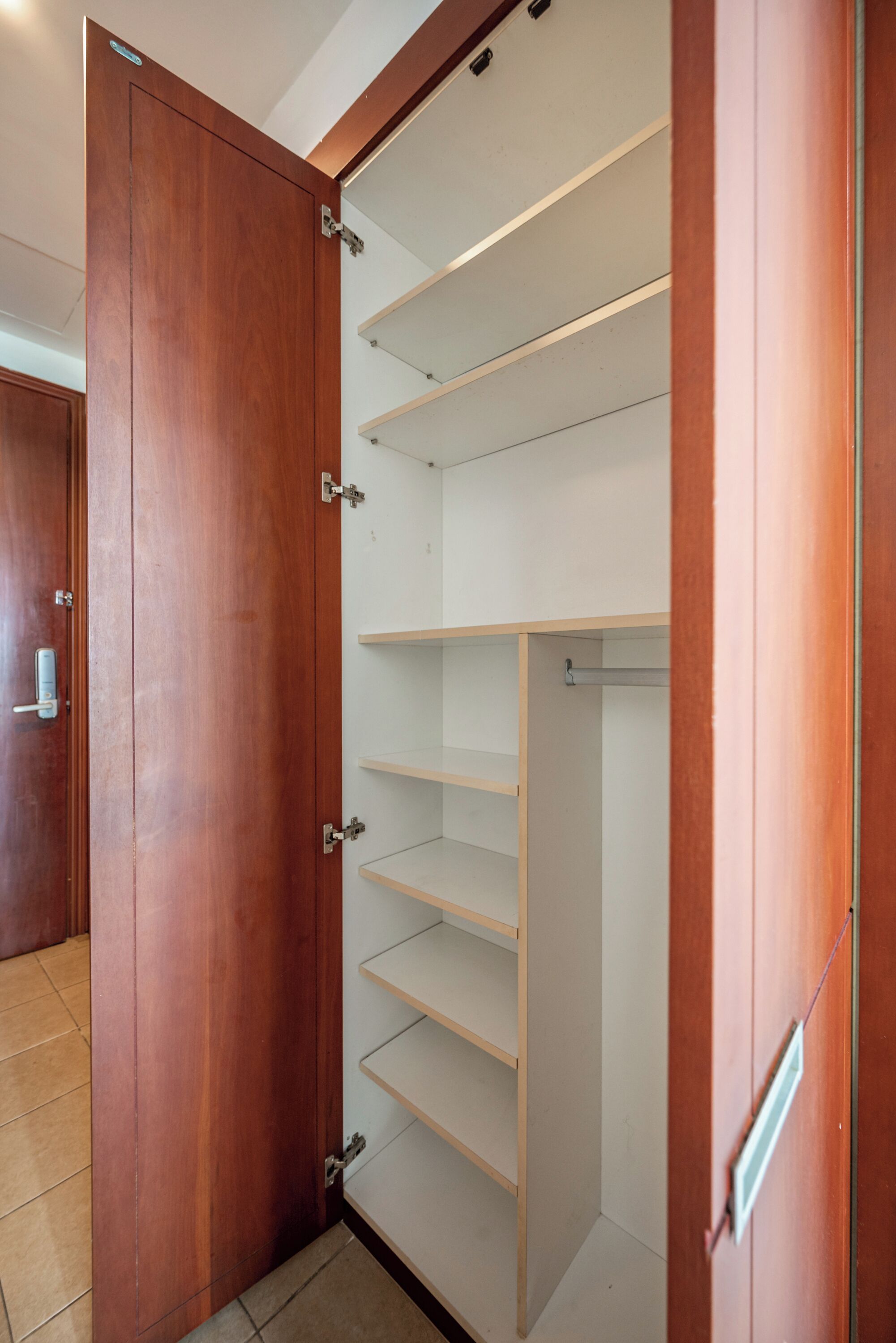 Une armoire en bois avec plusieurs étagères et une porte.
