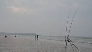 A beach with a fishing rod stand and people walking. - New waterfront rental with sea view (Plomodiern)