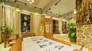 A traditional Japanese-style room with tatami flooring, a low table with calligraphy, and a shoji screen. - Danxia Mountain Fengqing Hostel (Renhua)