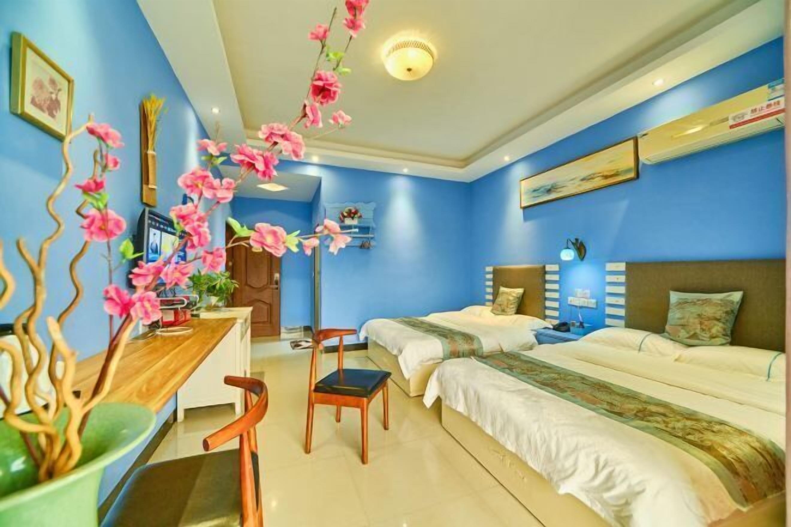 Une chambre d’hôtel avec deux lits, un bureau et une chaise.