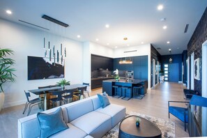 Ein modernes Wohnzimmer mit Sofa, Esstisch und Küchenzeile.