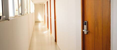 A long, narrow hallway with a wooden door marked with the number 309.