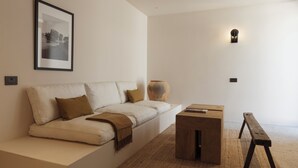 A modern living room with a sofa, a wooden coffee table, and a bench.