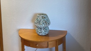 Ein Holztisch mit einer dekorativen Lampe und einem Schild mit der Aufschrift 'welcome' darüber.