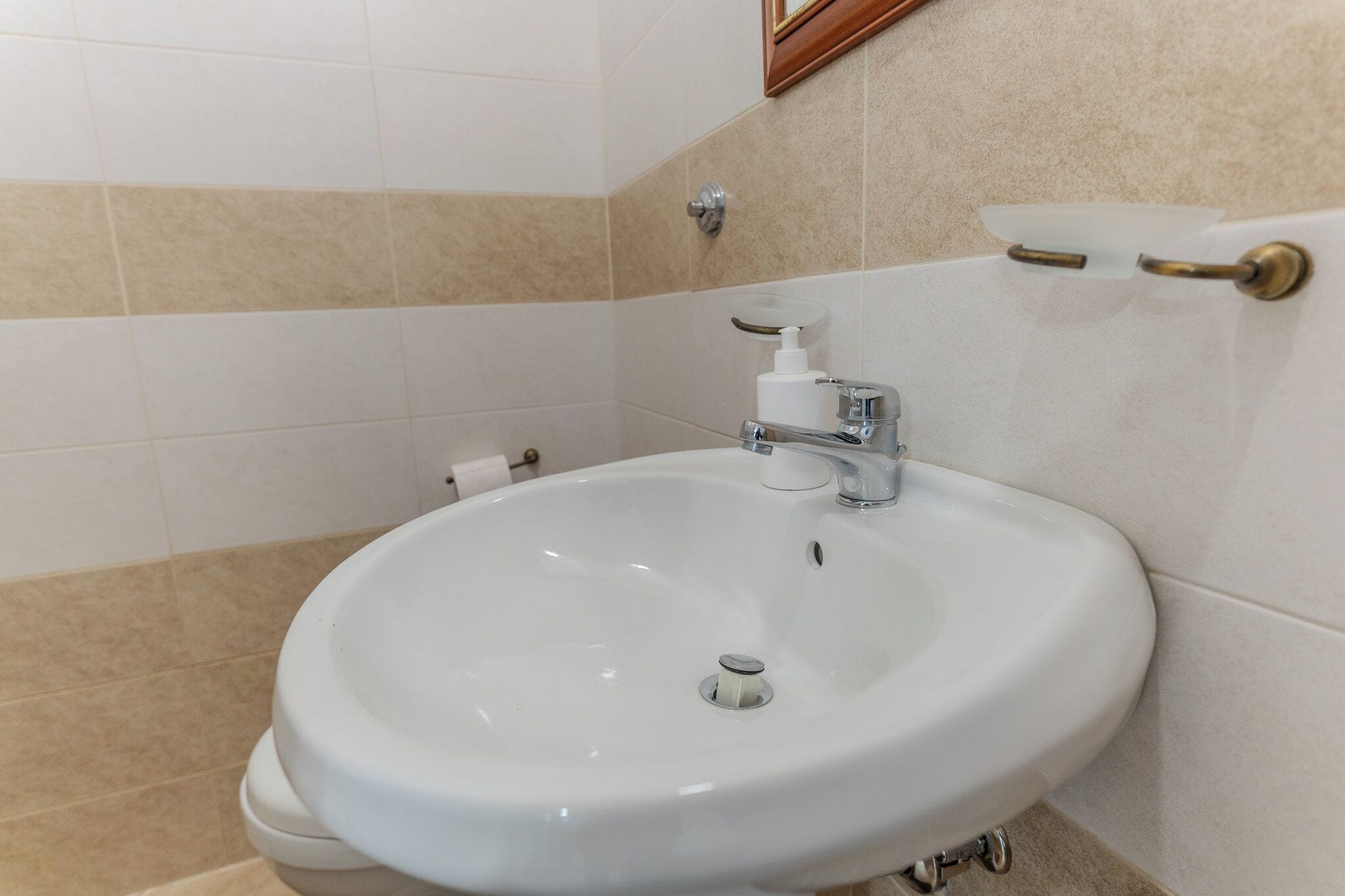 A bathroom with a white sink, a toilet, and a towel rack.