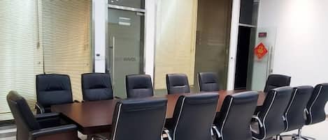 A conference room with a long table and multiple chairs.