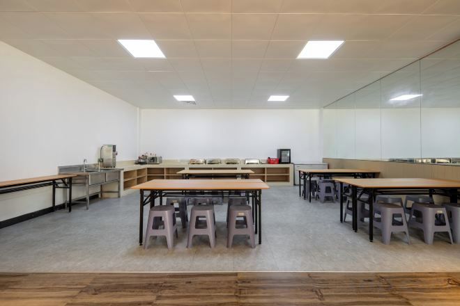 Ein Klassenzimmer mit Tischen, Stühlen und einer Tafel.