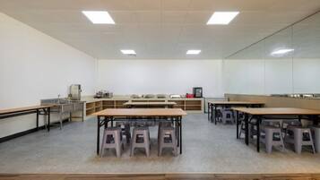 Ein Klassenzimmer mit Tischen, Stühlen und einer Tafel.