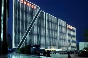 Un bâtiment moderne aux lignes verticales et à l’entrée imposante.
