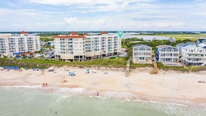 Ein Strandhotel mit mehreren Gebäuden, einem Sandstrand und Blick auf den Ozean.