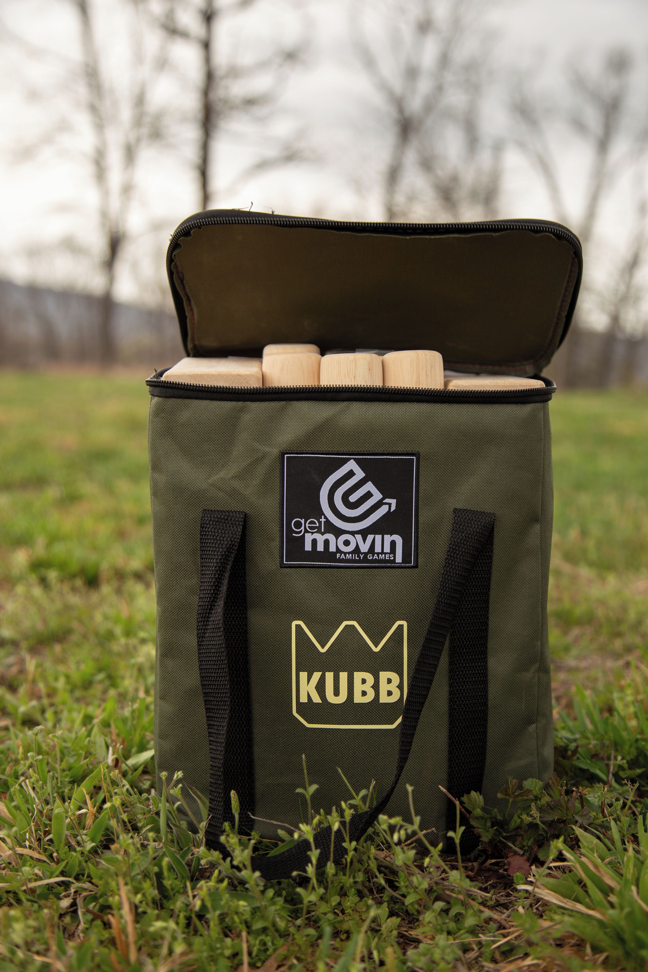 A green bag with a logo and text on it, placed on grass.