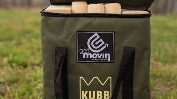 A green bag with a logo and text on it, placed on grass.