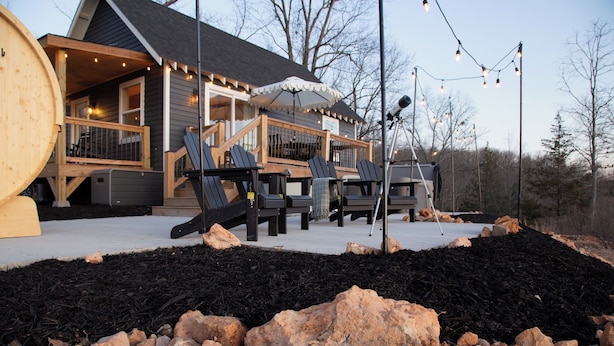 A wooden deck with outdoor seating and a large barrel.
