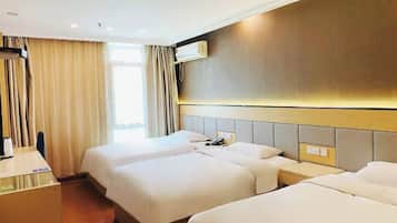 Quarto de hotel com duas camas, uma escrivaninha e um ar condicionado fixado na parede.