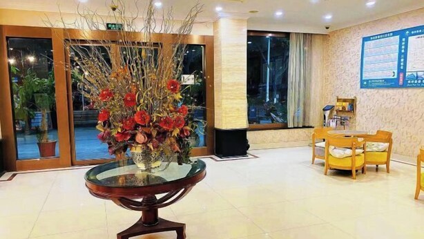 A lobby with a glass-top table, chairs, a large window, and a wall-mounted information board. - GreenTree Inn Shanghai Songjiang Xinqiao Jiuxin Road Express Hotel (Shanghai)