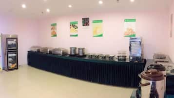 A buffet setup with a counter, food containers, and a water dispenser.