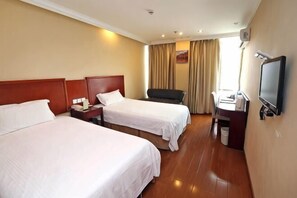 A hotel room with two beds, a desk, a chair, a TV, and a window with curtains.