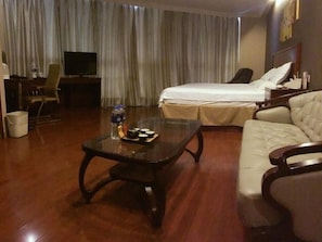 A hotel room with a bed, a sofa, a television, and a coffee table. - GreenTree Inn Shanghai Songjiang Xinqiao Jiuxin Road Express Hotel (Shanghai)