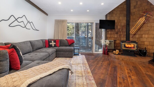 Un soggiorno moderno con un divano componibile, un camino e una grande finestra.