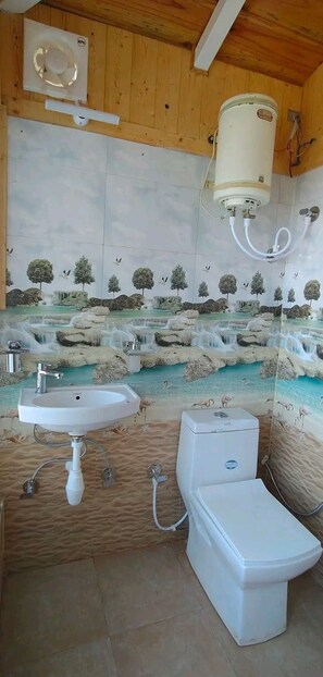 A bathroom with a sink, toilet, and a wall-mounted heater. - Luxsugero Moonlight (Bhimtal)