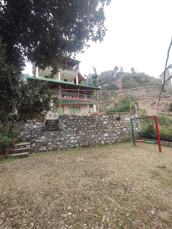A two-story building with a stone staircase leading to a balcony. - Luxsugero Moonlight (Bhimtal)