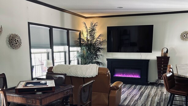 Una sala de estar con chimenea, televisión y comedor con mesa y sillas.
