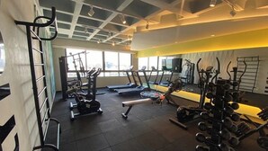 Un gimnasio con cintas de correr, máquinas de pesas y una barra para dominadas.