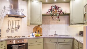 Una cocina con estufa, horno y diferentes utensilios.