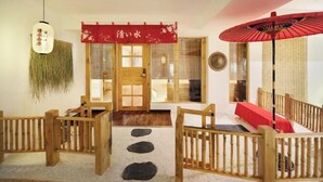 A traditional Japanese interior with tatami flooring, a shoji screen door, a red hanging scroll, and a red fan. - Shangshanju Yangxin Chanjing Hotel (Leshan)