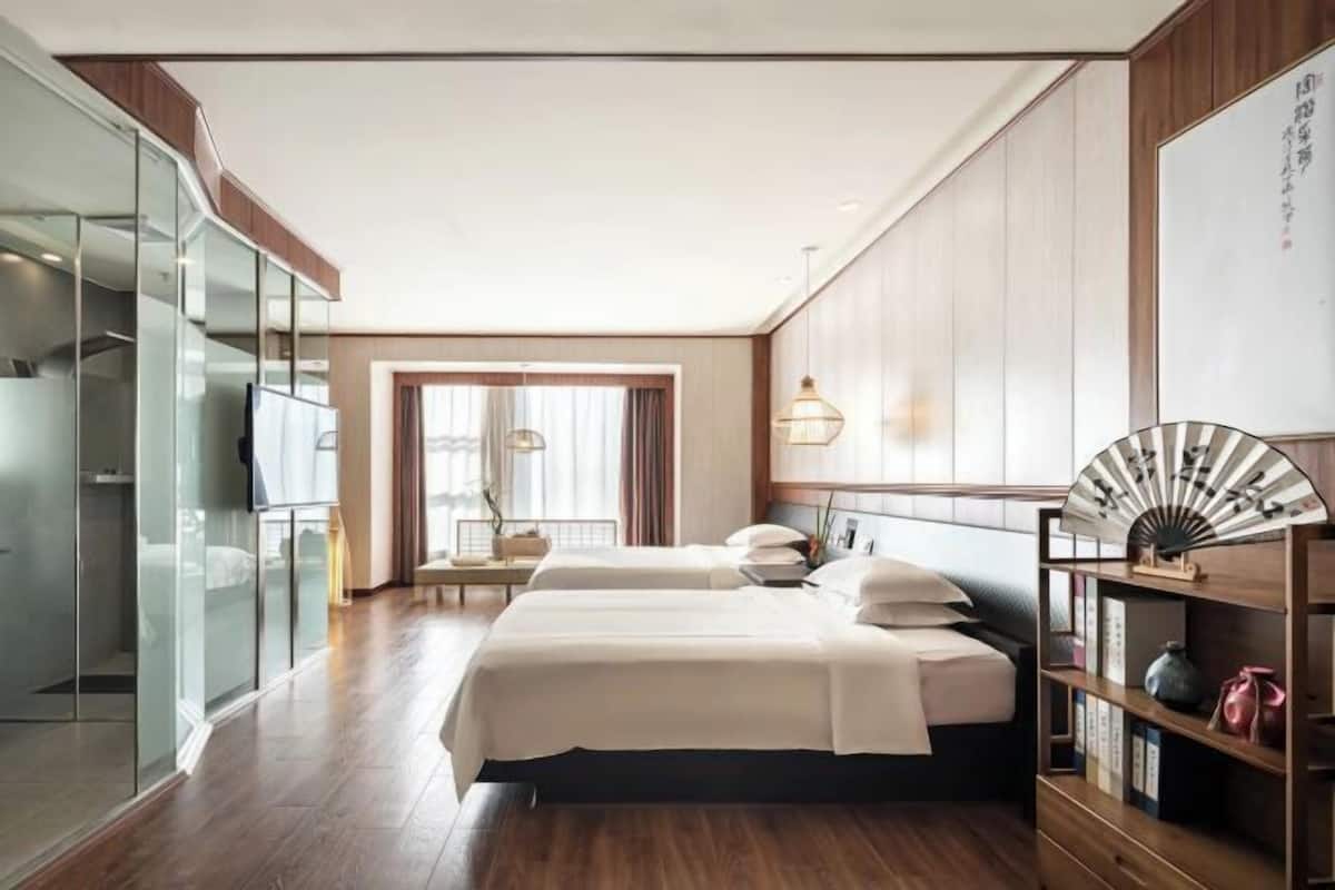 Ein Hotelzimmer mit Bett, Nachttisch, Kleiderschrank und Blick ins Freie.