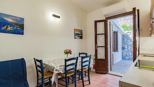 Un comedor con una mesa, sillas y un cuadro en la pared.