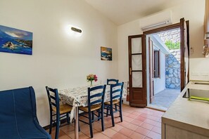 Un coin repas avec une table, des chaises et un tableau accroché au mur.
