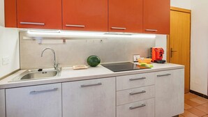 Una cocina compacta con un lavamanos, un microondas y una cafetera.