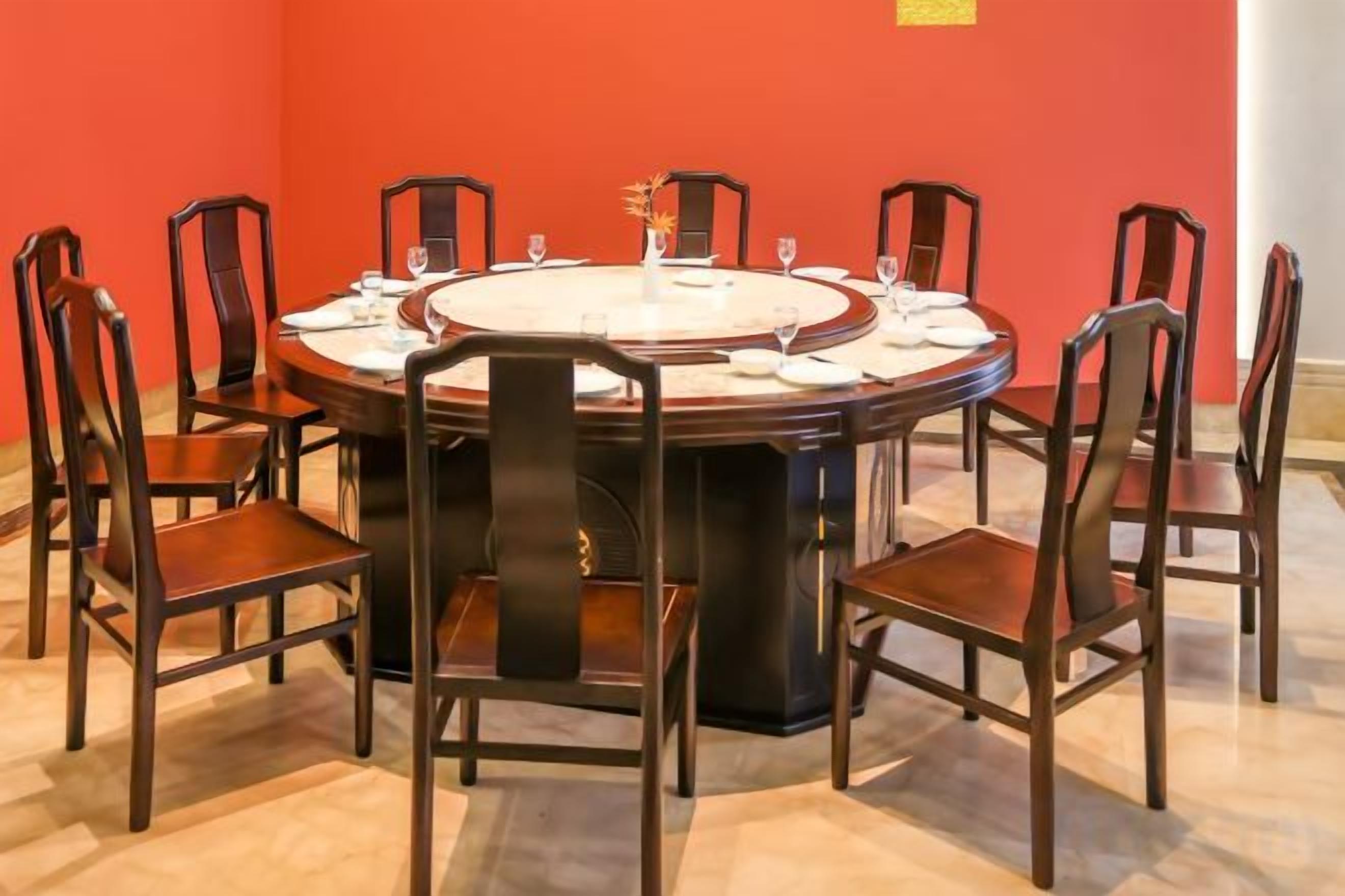 A round dining table with chairs, set for a meal.