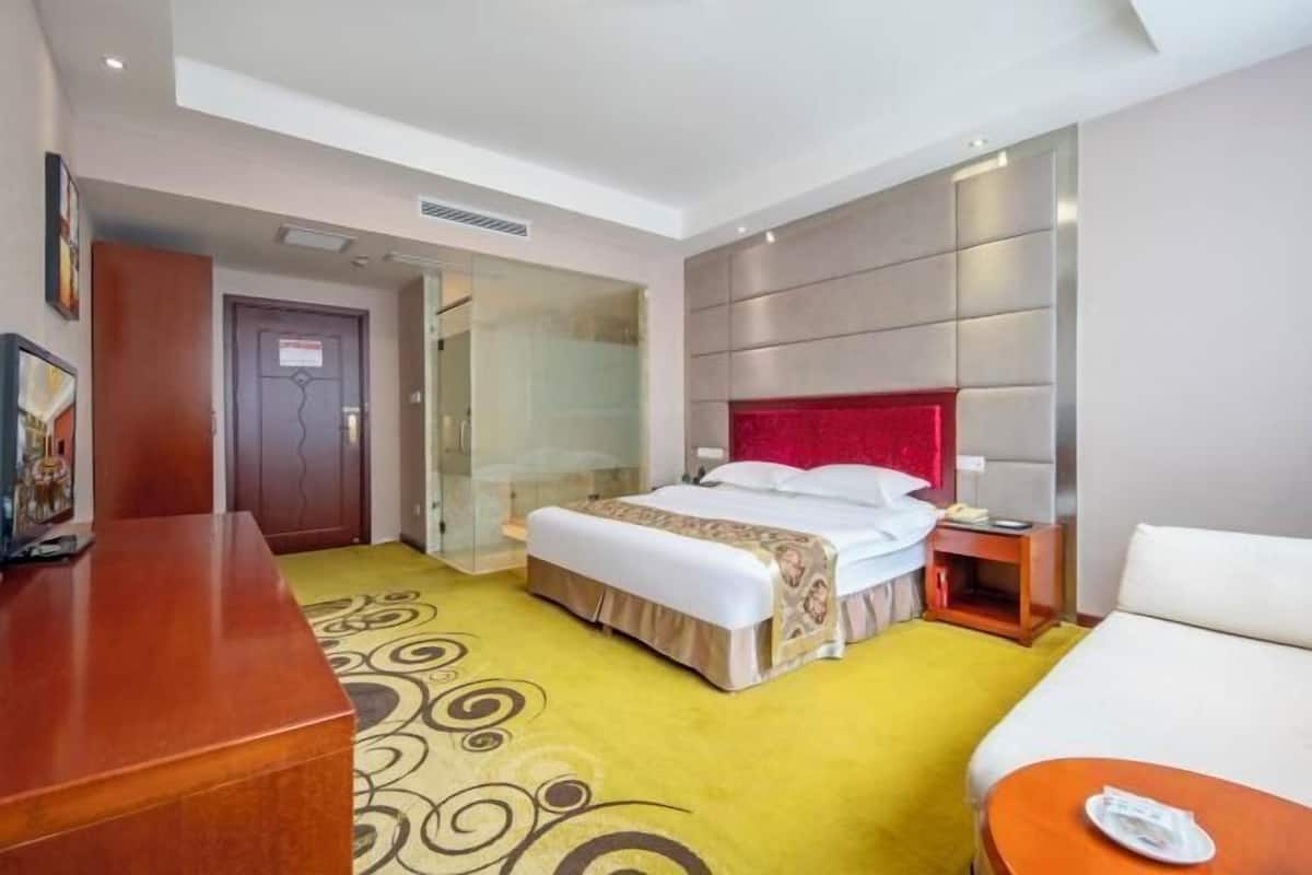 Una habitación de hotel con cama, mesita de noche y escritorio.