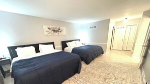 A hotel room with two beds, a patterned rug, and a painting on the wall. - 6 Kings Ping-Pong Gazebo! (Northbrook)