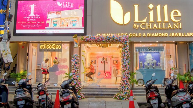 A storefront with a sign for 'Lille By Challani' jewelry store, a balcony with railings, and several parked scooters. - Daffodils by La Maison Charu  (Puducherry)